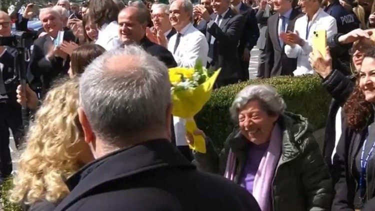 教皇の祝福を受ける人々と花束を持つカルメーラ・マンクーゾさん　2025年3月23日、ローマ、ジェメッリ病院広場