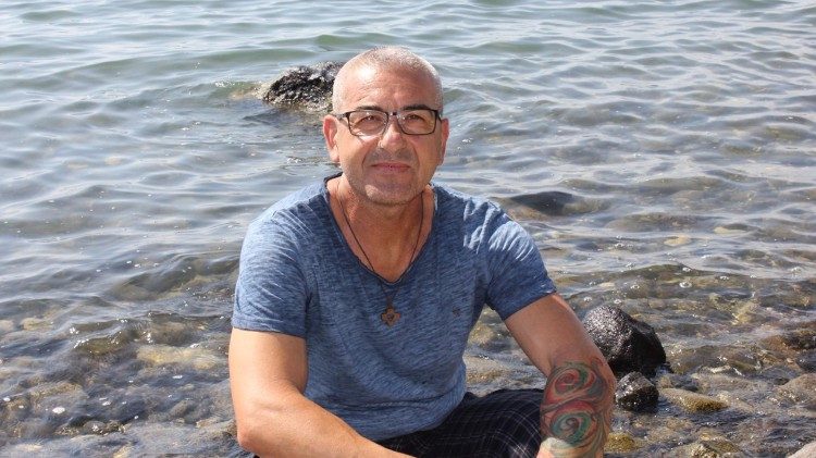 Giovanni siede sulle rive del mare di Tiberiade in Terra Santa.