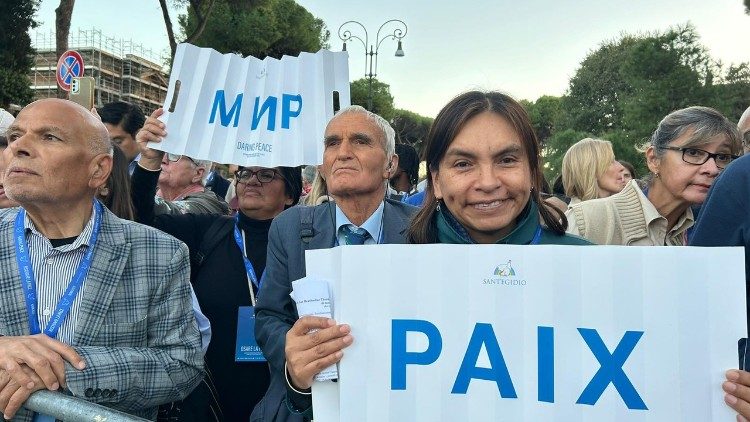 Marilu Grados hält am Kolosseum  ein Schild mit der Aufschrift „Paix" (französisch für Frieden)