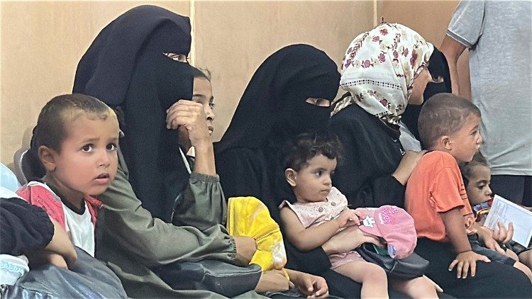 Mothers and their children wait to see the doctor at a temporary clinic operated by the NECC