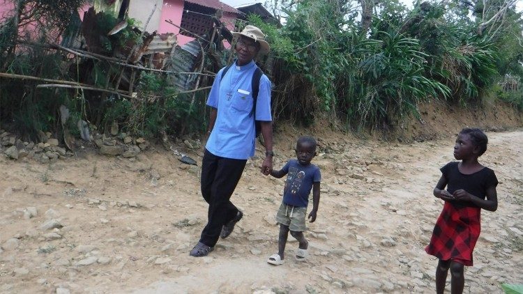 Le p&egrave;re ha&iuml;tien No&euml;l Jean-Baptiste en promenade avec des enfants