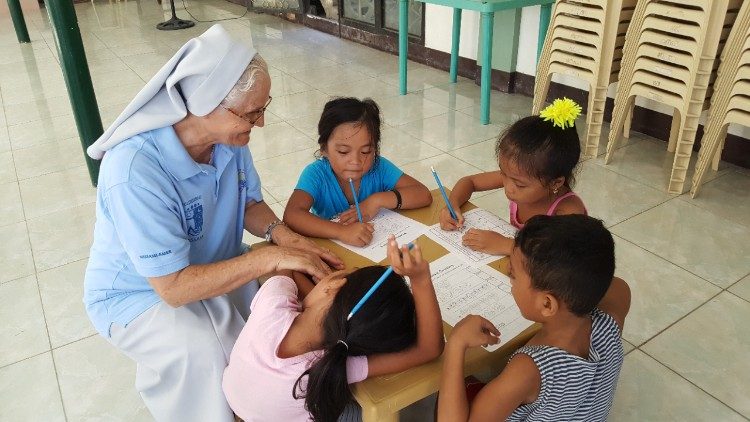 Sr. Lourdes teaches children to write