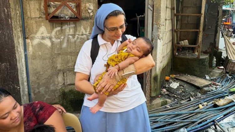 Sr. Liliam drž&iacute; v n&aacute;ruč&iacute; d&iacute;tě z manilsk&eacute;ho předměst&iacute; Baseco