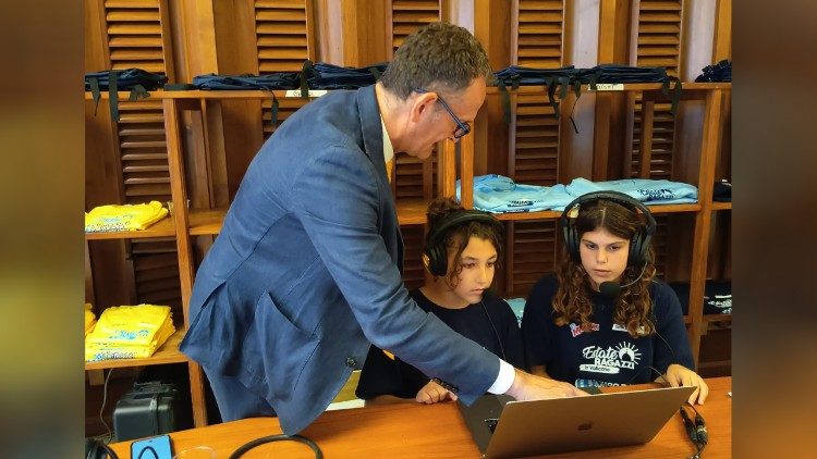 Massimiliano Menichetti, responsabile di Radio Vaticana - Vatican News, assieme a due delle giovani "giornaliste per un giorno" di Estate Ragazzi in Vaticano 2026
