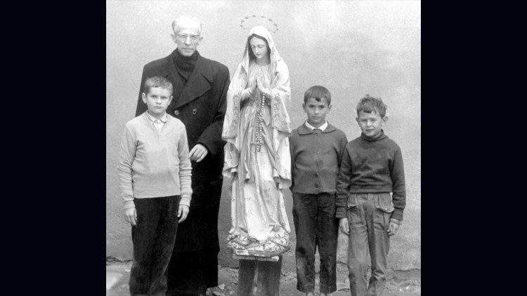 Findysz atya a Szűzanya szobrával és kisgyerekekkel  