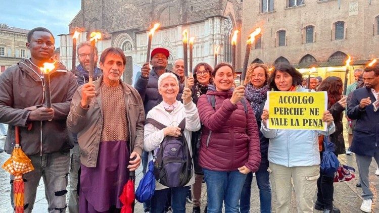 Zasvěcení mužové a ženy doprovázejí migranty při manifestaci v Boloni