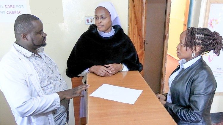 Sr. Purity Mathenge Consulting hovoř&iacute; se zaměstnanci střediska, Kelvinem Mwegou a Ann Wangari