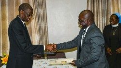 ZCBC's Fr Travis Moyo and the Catholic University of Zimbabwe (CUZ)'s Prof Ben Nyambo exchange the signed documents.