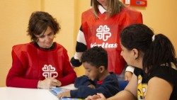 Il lavoro di accoglienza dei volontari di Caritas Española con un bambino immigrato. 
