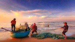 வலைகளைத் தயார்படுத்திக் கொண்டிருக்கும் சில மீனவர்கள்.